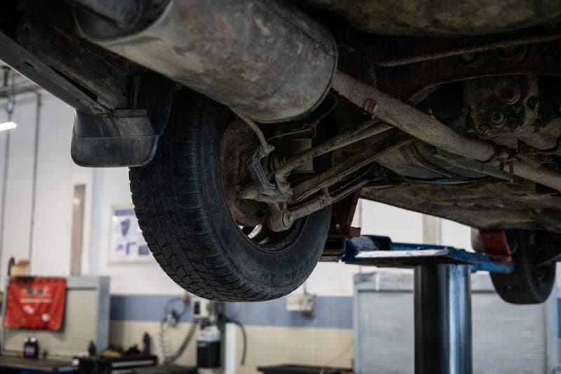 Close view of a car undercarriage at a service station