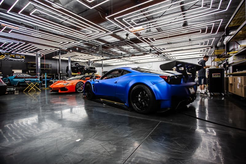 Low sports cars parked in a modern automotive workshop