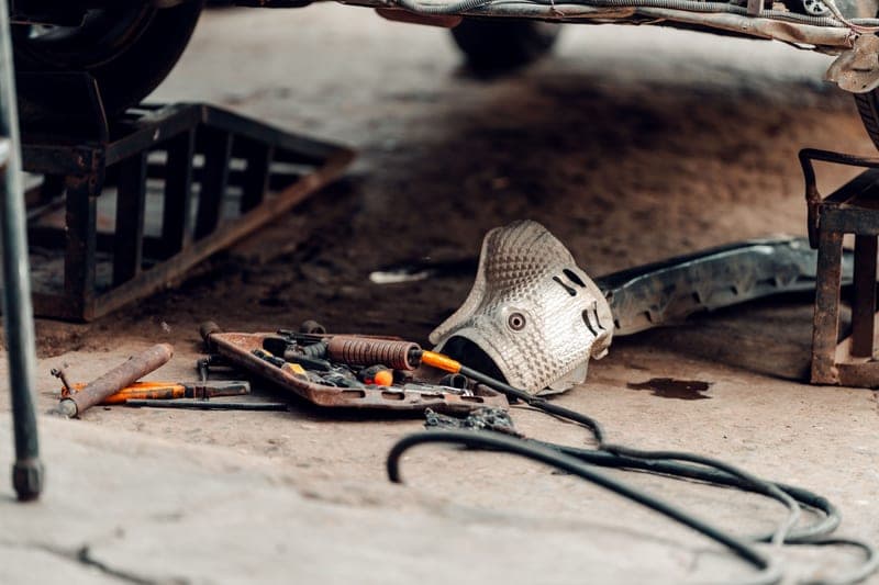 Automotive hand tools and equipment arranged on a workshop surface