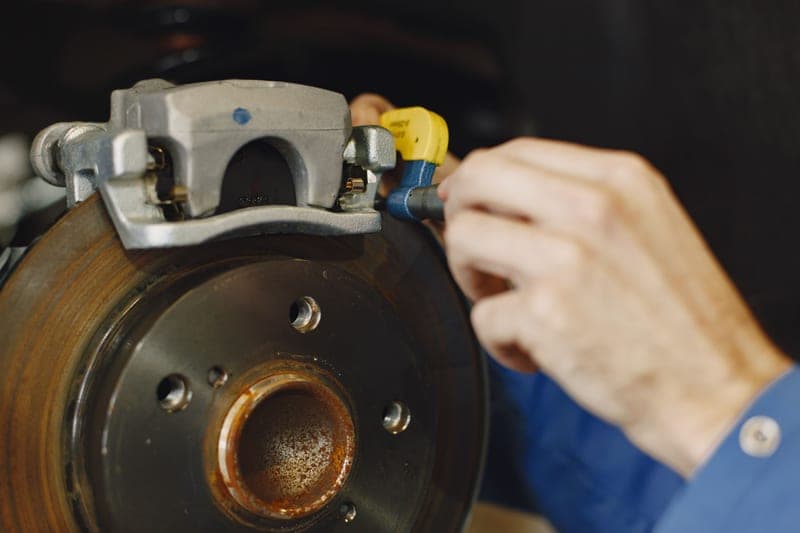 A mechanic working on a car disc brake