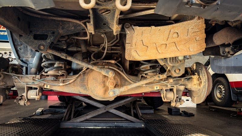 Close view of a car suspension assembly during a repair in a garage