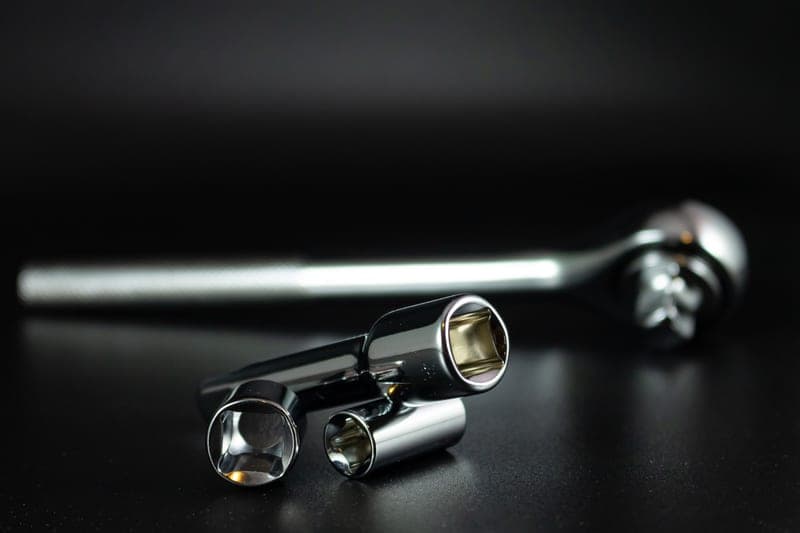 A chrome socket wrench set photographed against a dark background