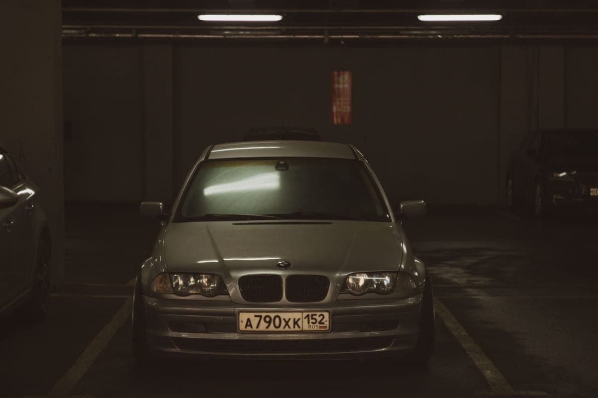A gray car parked indoors in a dimly lit garage